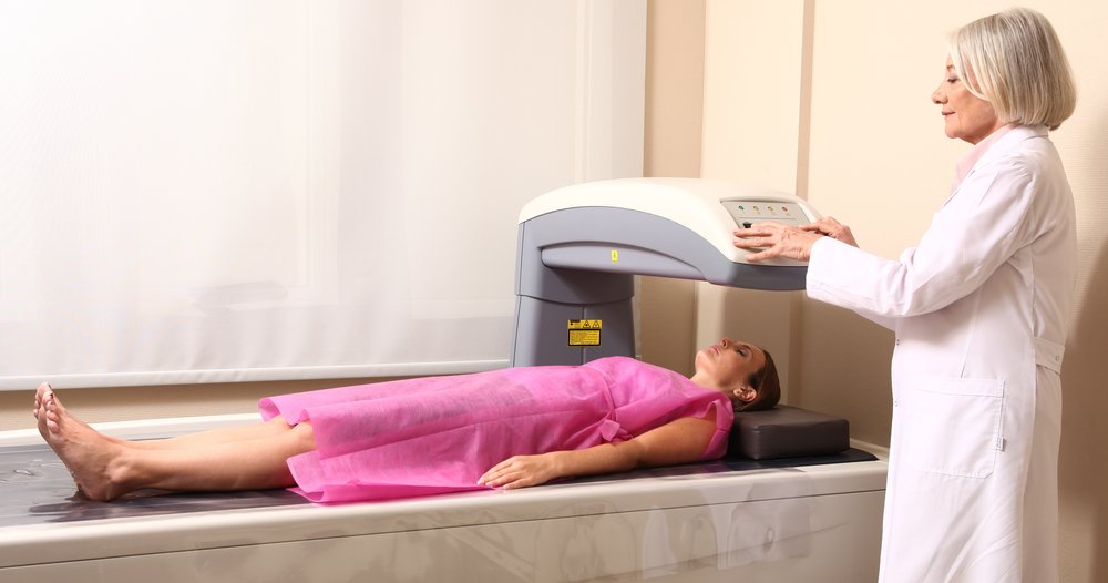 Female,Doctor,Examining,Woman,In,40s,At,Bone,Densitometer,Machine.